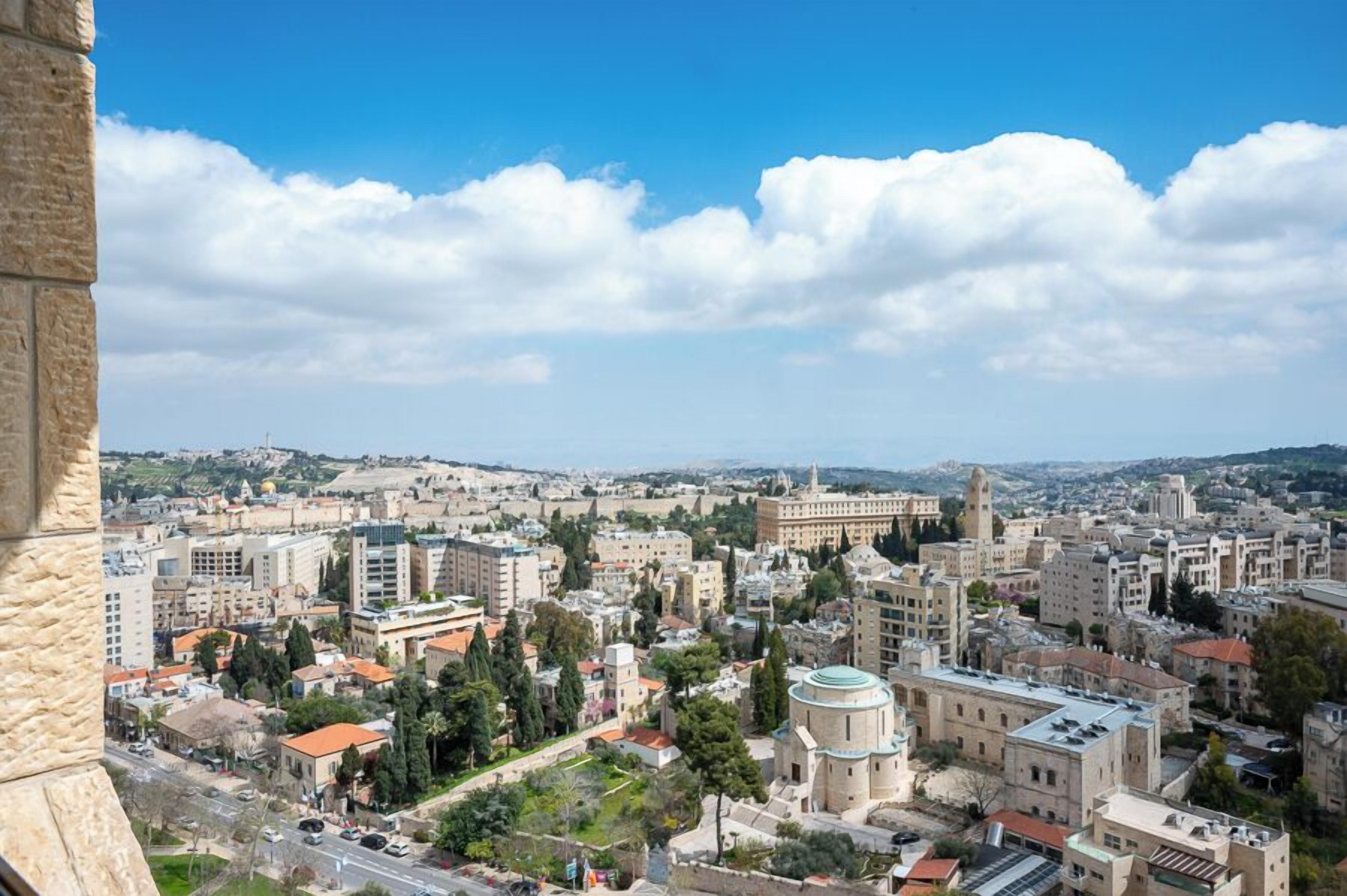 A cityscape with historic architecture, including a prominent building with a dome and a tall tower.