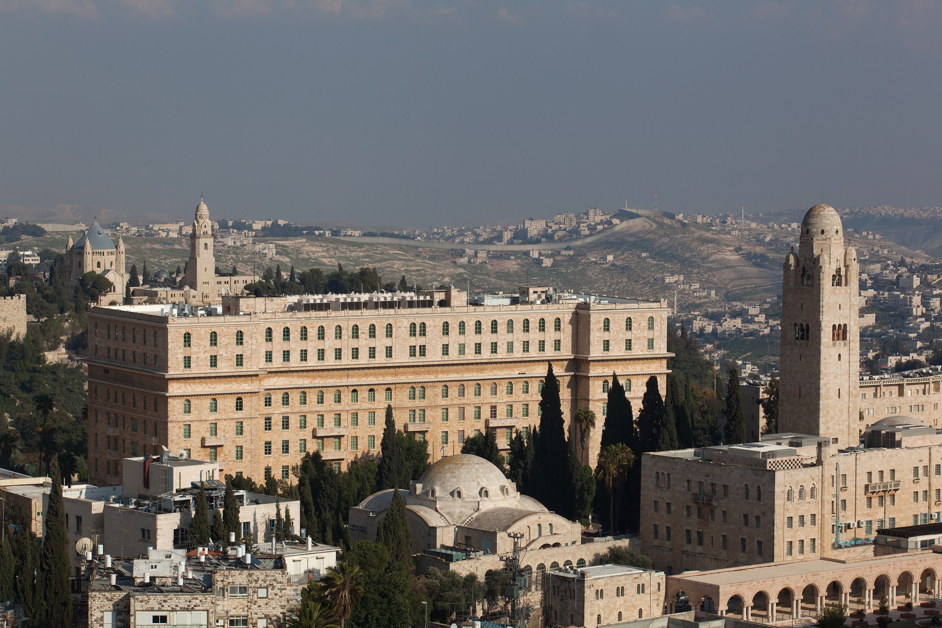 A large building with multiple towers and domes, surrounded by other buildings and trees.