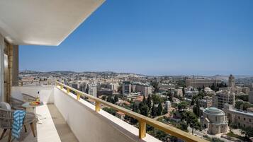 A balcony with a view of a cityscape, including buildings and a mosque.