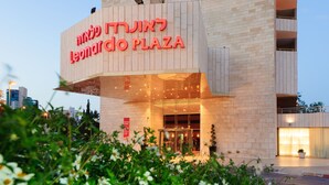 Exterior del Leonard Plaza, con una entrada destacada y un letrero en hebreo.