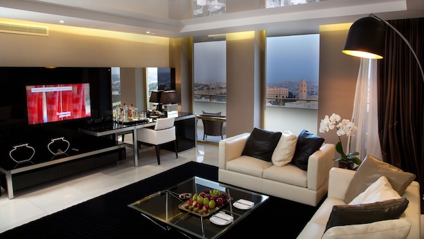 Una sala de estar moderna con televisor, comedor y sofá.