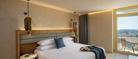 Habitación de hotel moderna con una cama grande, mesitas de noche y vistas a la ciudad desde un balcón.