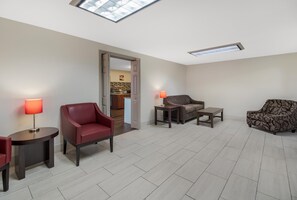 A spacious living area with a high ceiling, a skylight, and a view into a kitchen area. - Red Roof Inn & Suites Jackson, TN (Jackson)
