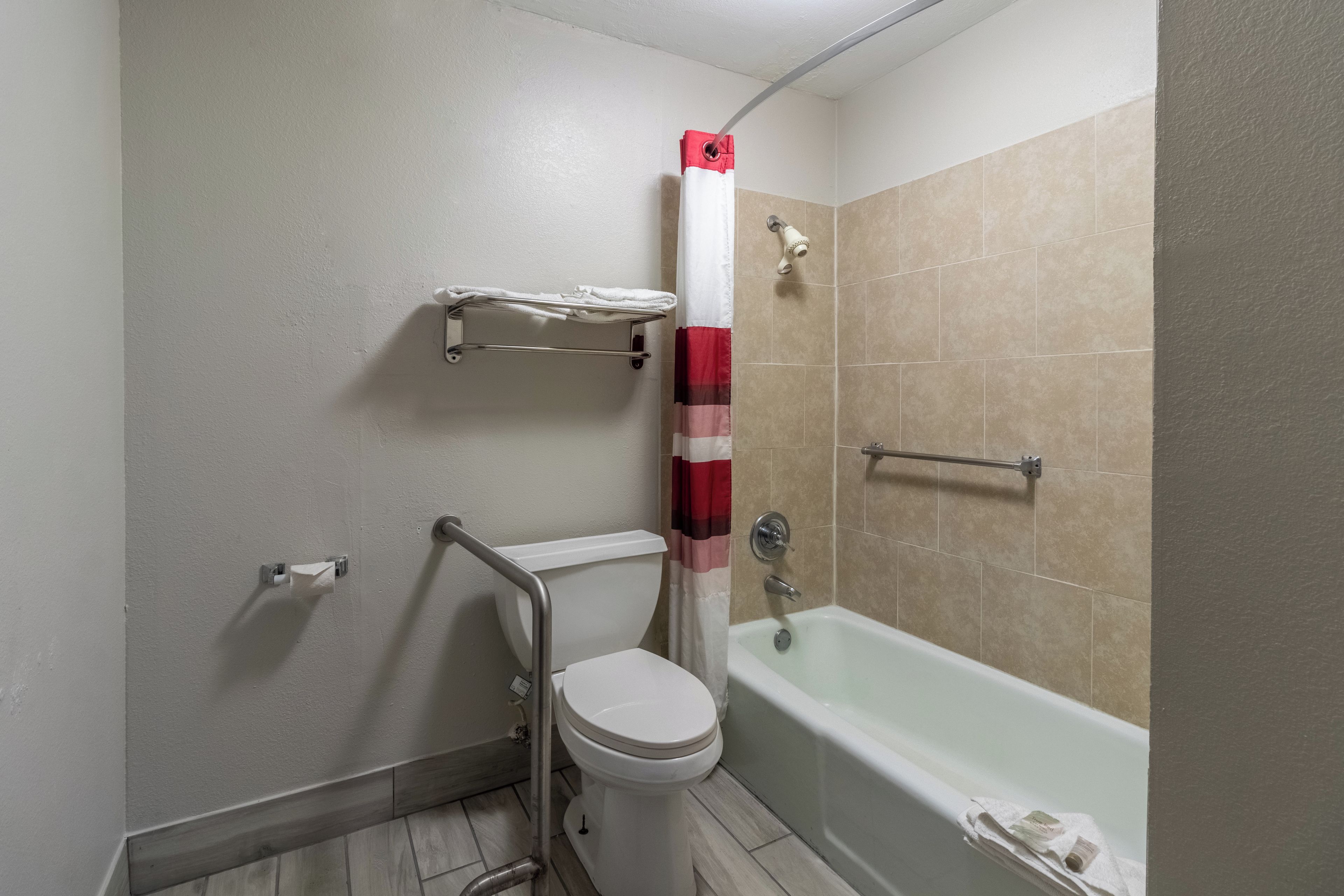 Une salle de bain avec des toilettes, une douche et une baignoire.