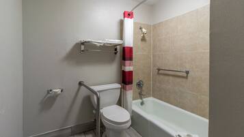 Une salle de bain avec des toilettes, une douche et une baignoire.