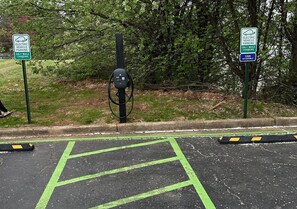A parking area with electric vehicle charging stations, marked parking spaces, and a van accessible sign. - Red Roof Inn & Suites Jackson, TN (Jackson)