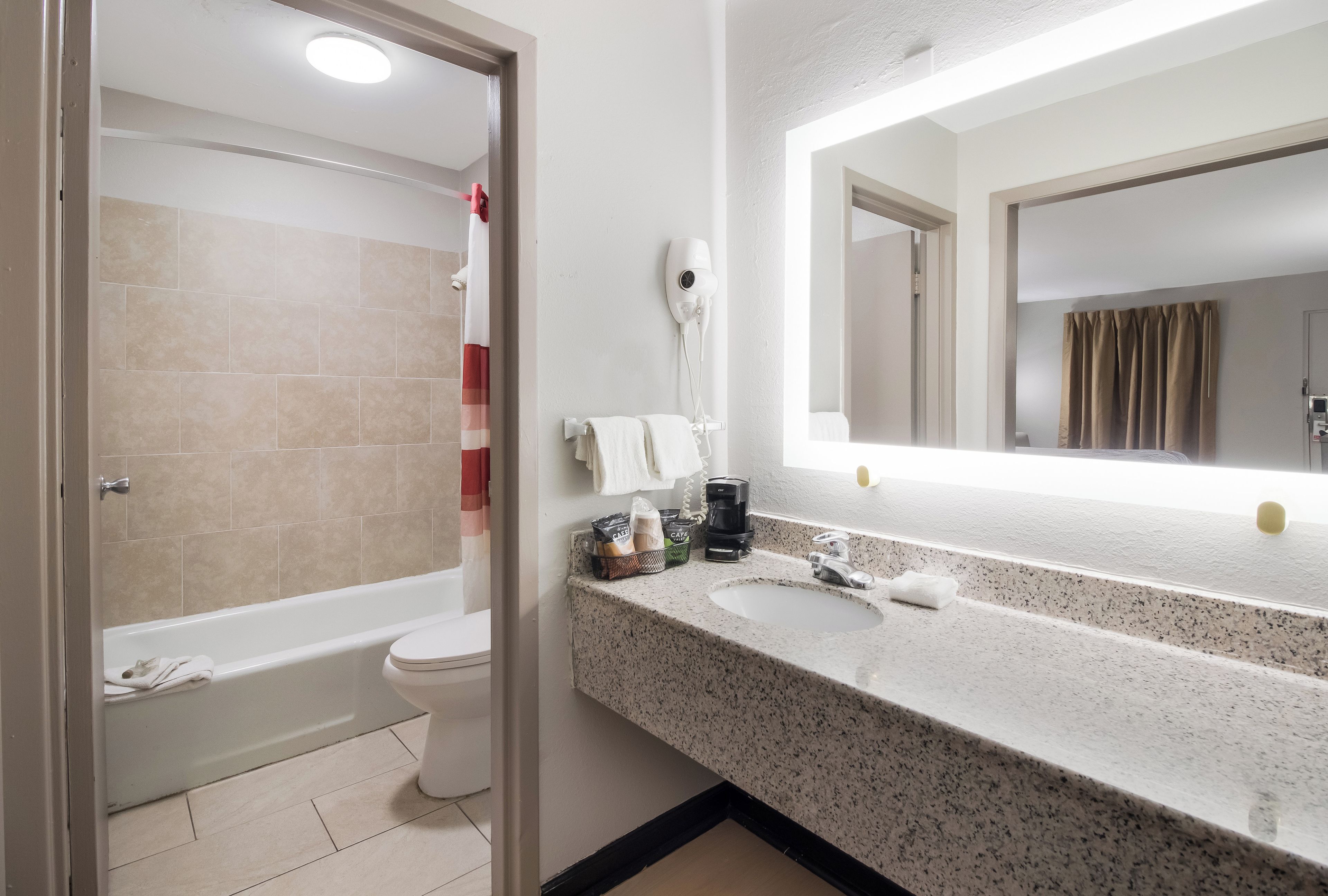 A bathroom with a bathtub, toilet, and a sink with a mirror.