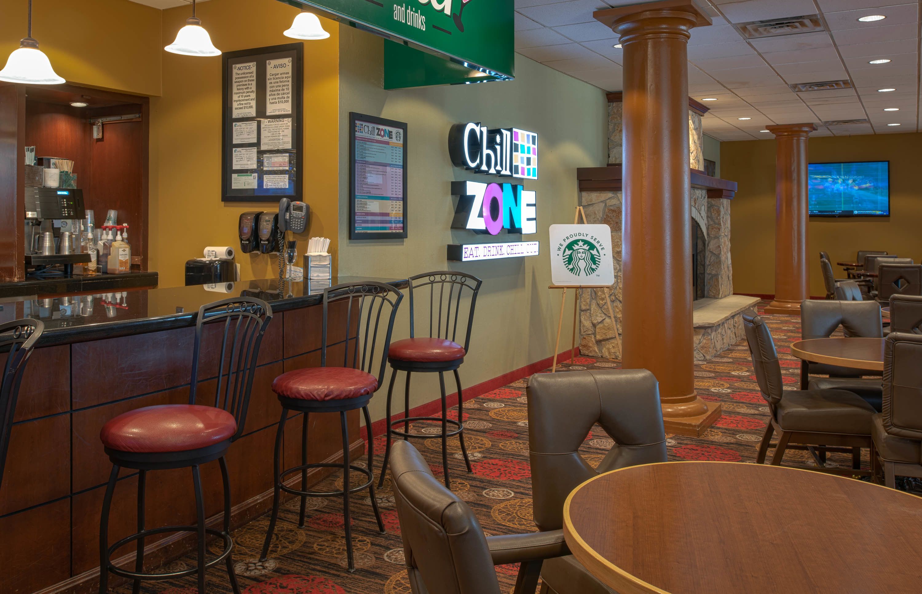 A restaurant area with a bar, seating, and a Starbucks sign.
