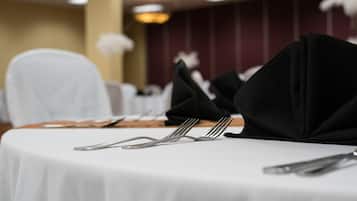 A table set with a white tablecloth, black napkins, and silverware.