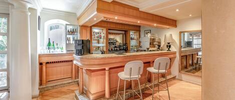 A spacious kitchen with a central island, bar area, and seating.