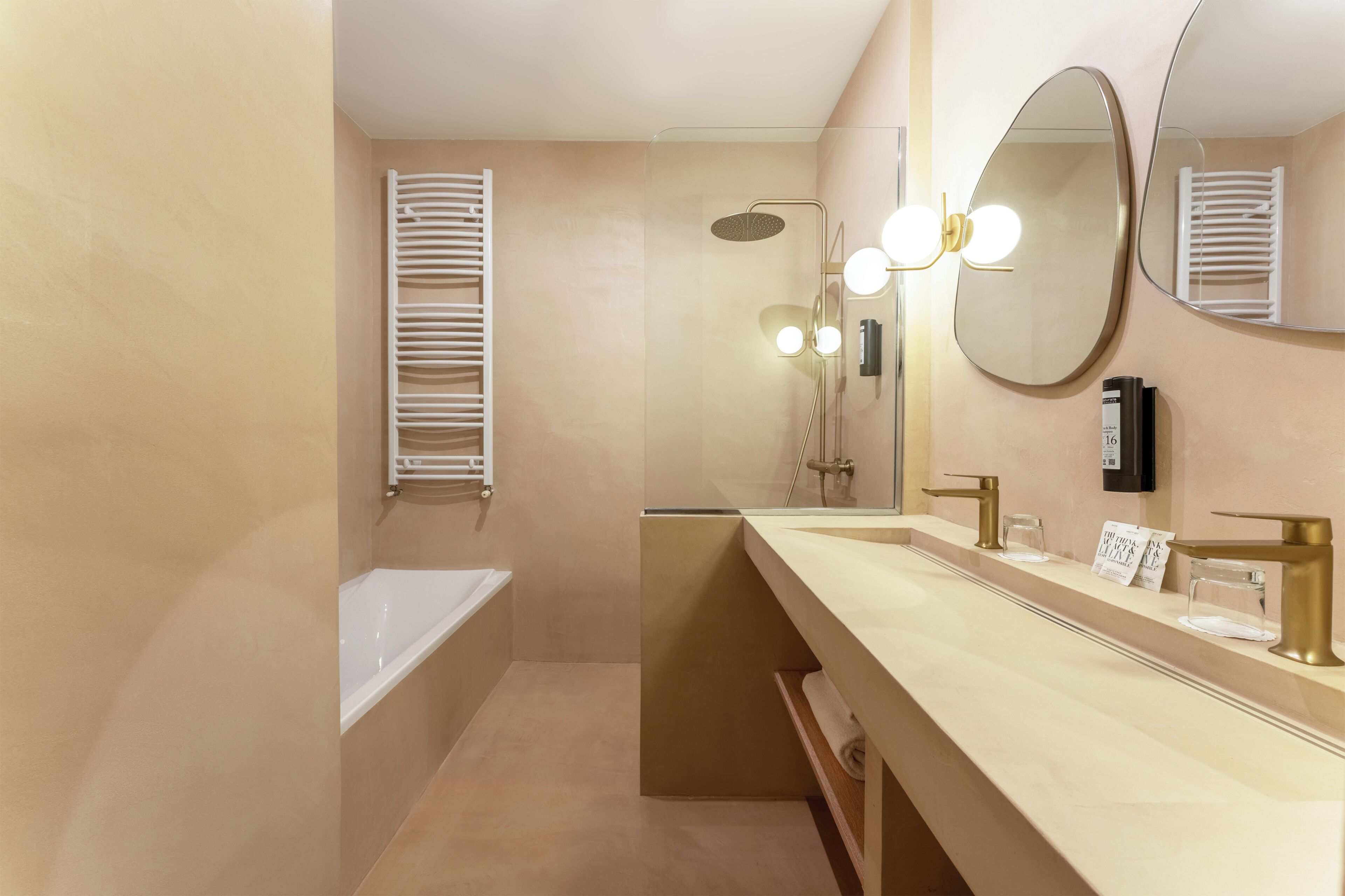 A modern bathroom with a bathtub, a shower, a vanity with a mirror, and a towel rack.