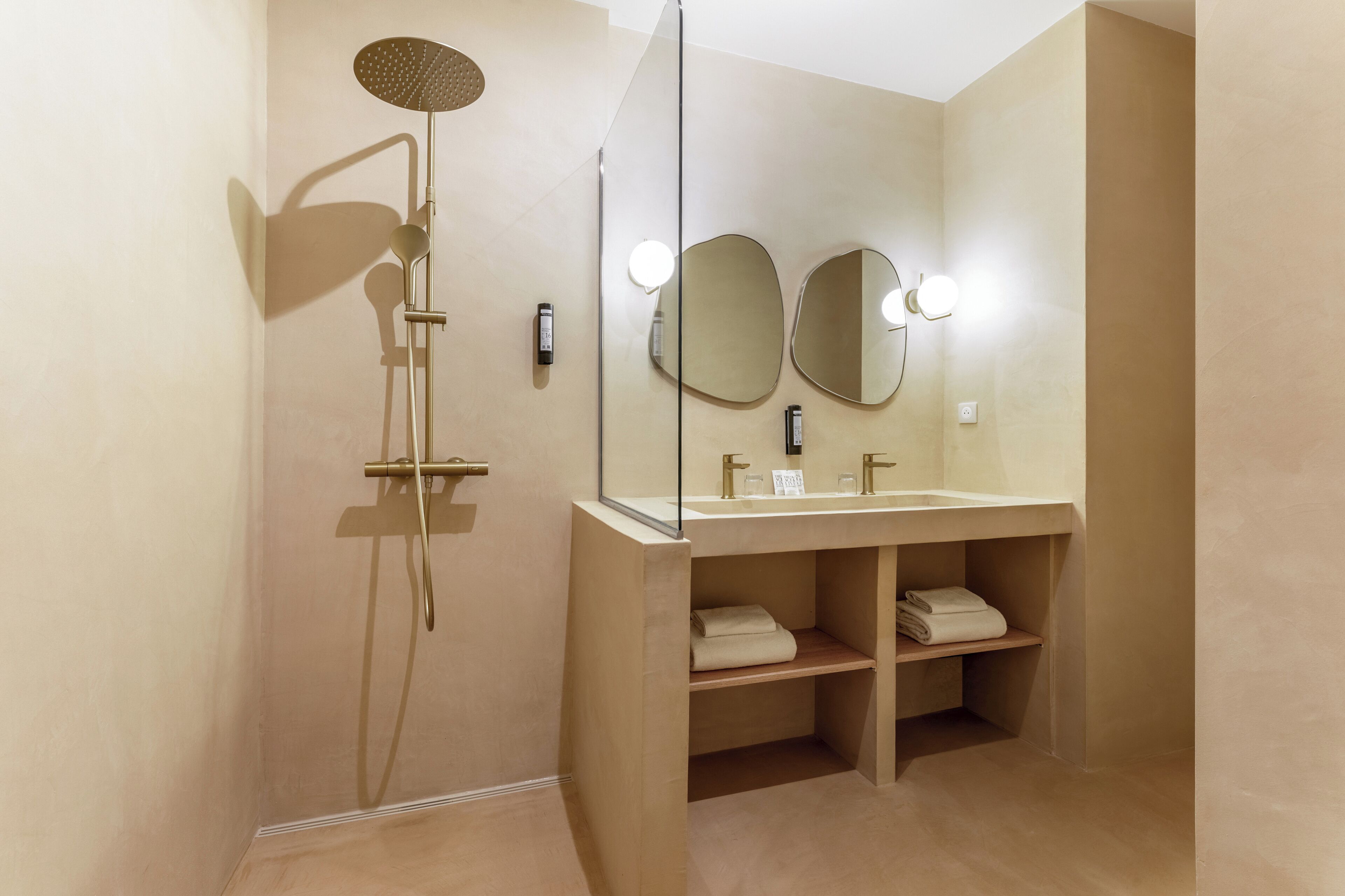 A modern bathroom with a shower, two mirrors, a sink, and a towel rack.