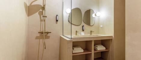A modern bathroom with a shower, two mirrors, a sink, and a towel rack.