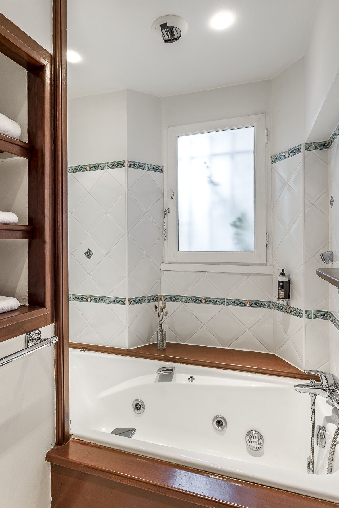 Un baño con bañera, ventana y espejo.