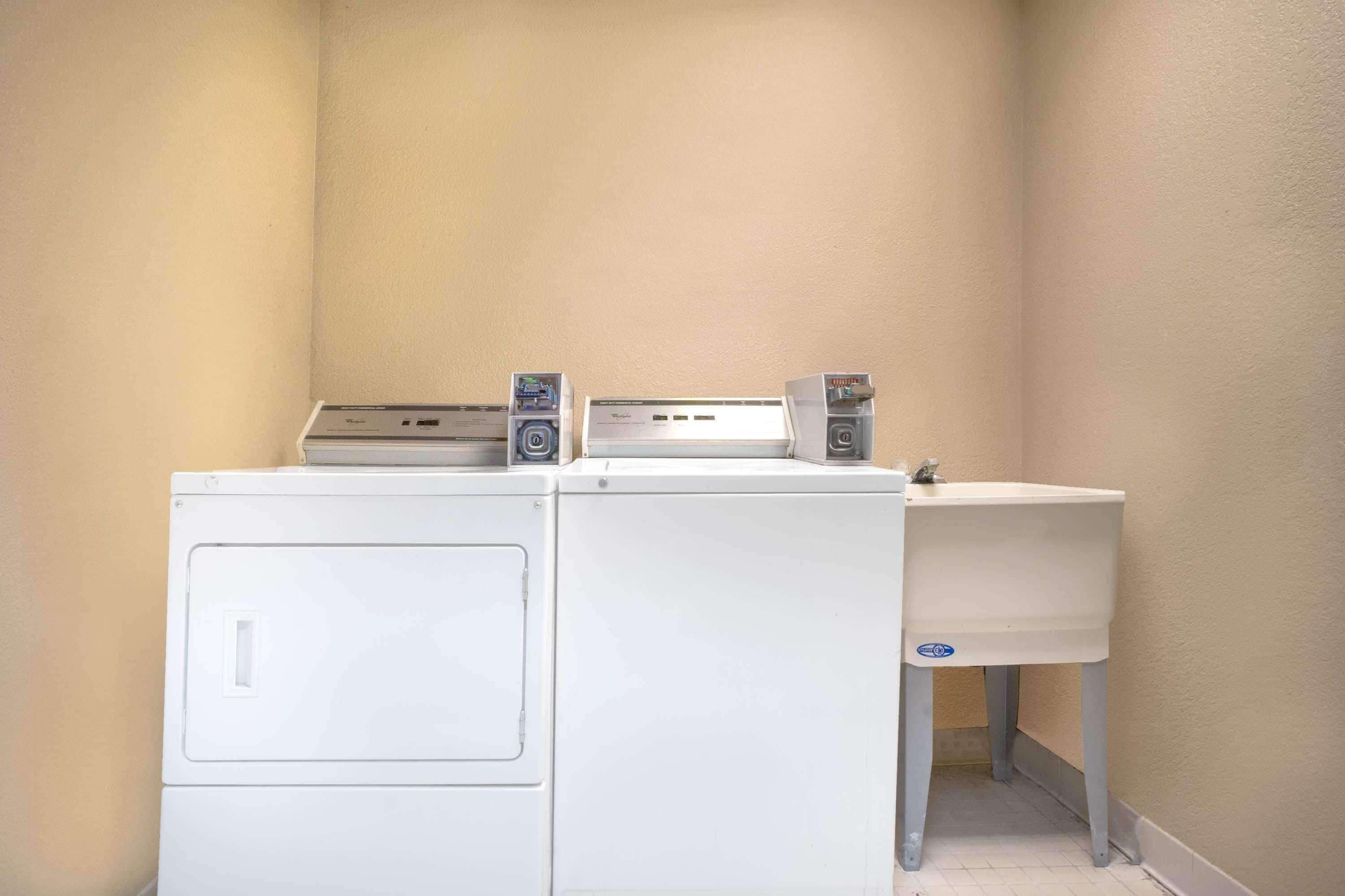A laundry area with two washing machines and a sink.