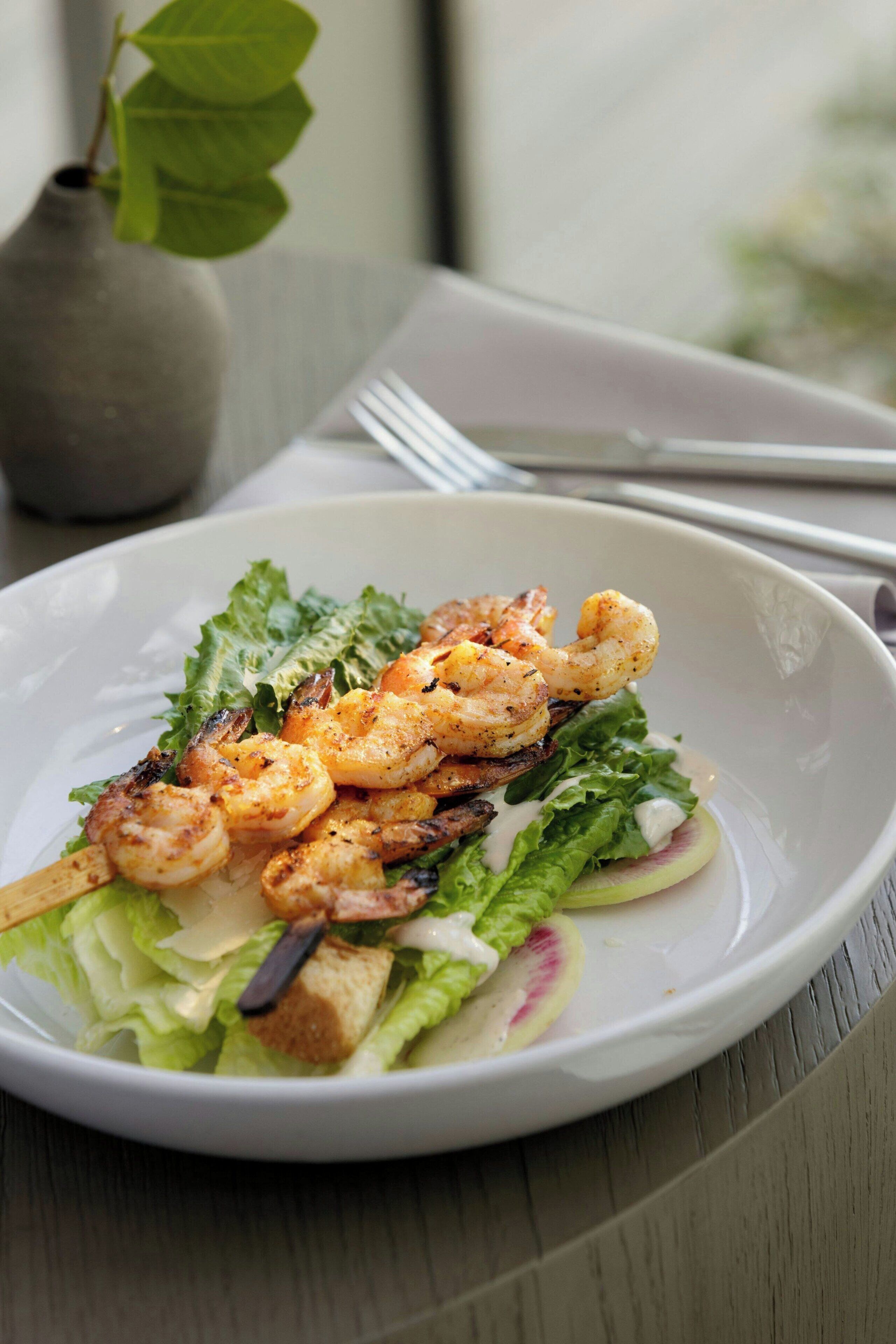 A plate of shrimp and salad on a table.