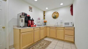 A compact kitchen with a coffee maker, microwave, and a small sink.