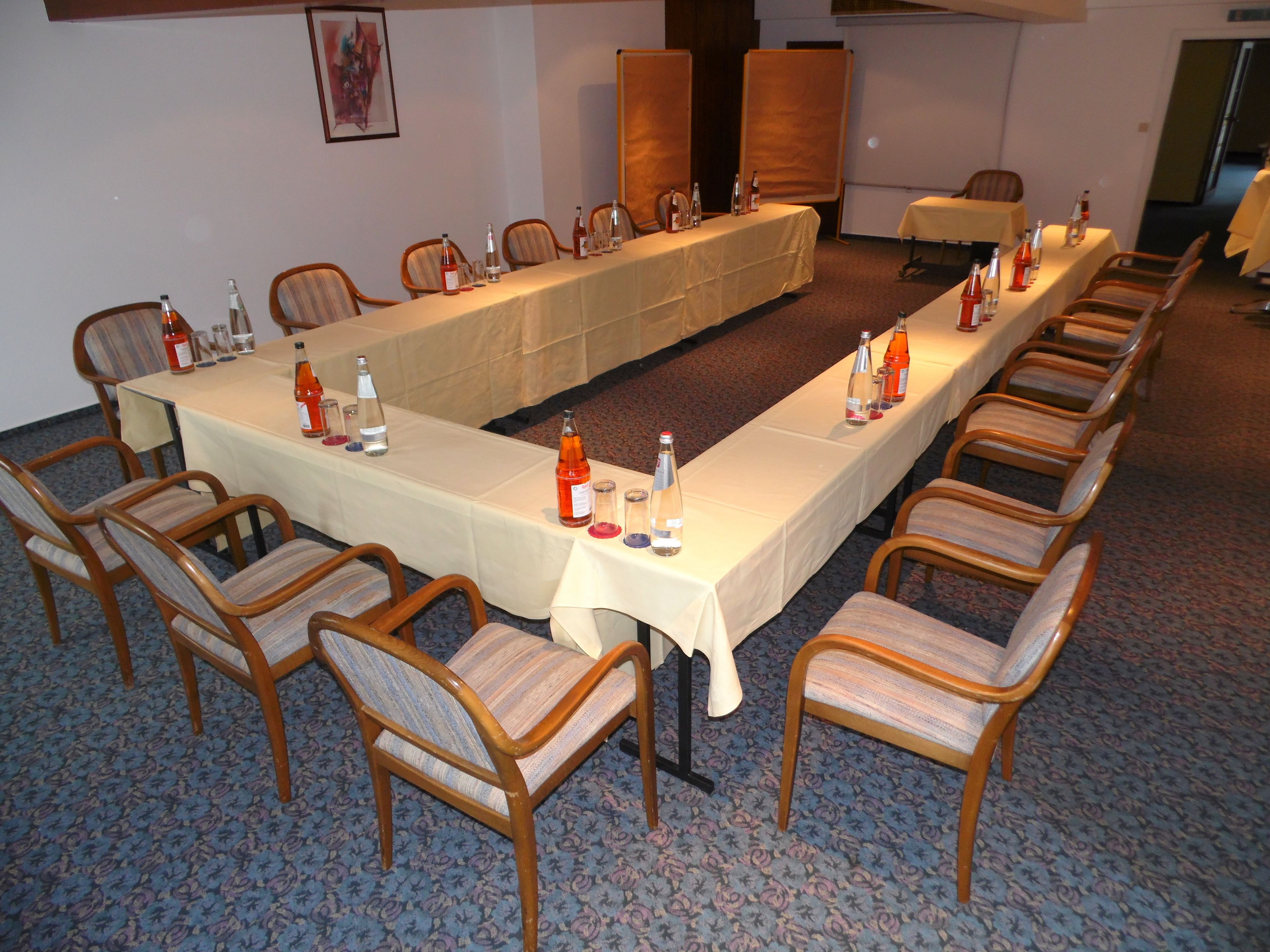 A conference room with a long table, chairs, and bottles of water.