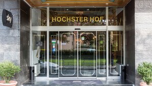 The entrance of a hotel with a prominent sign reading "HOTEL" and "HOCHSTER HOF" above the doors.