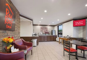 A hotel lobby with a reception desk, a seating area with chairs, a kitchenette, and a dining area with a table and chairs. - Red Roof Inn Dillon, SC (Dillon)