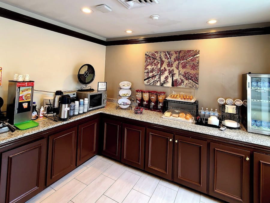 Una cocina con estación de café, plancha para gofres y refrigerador.
