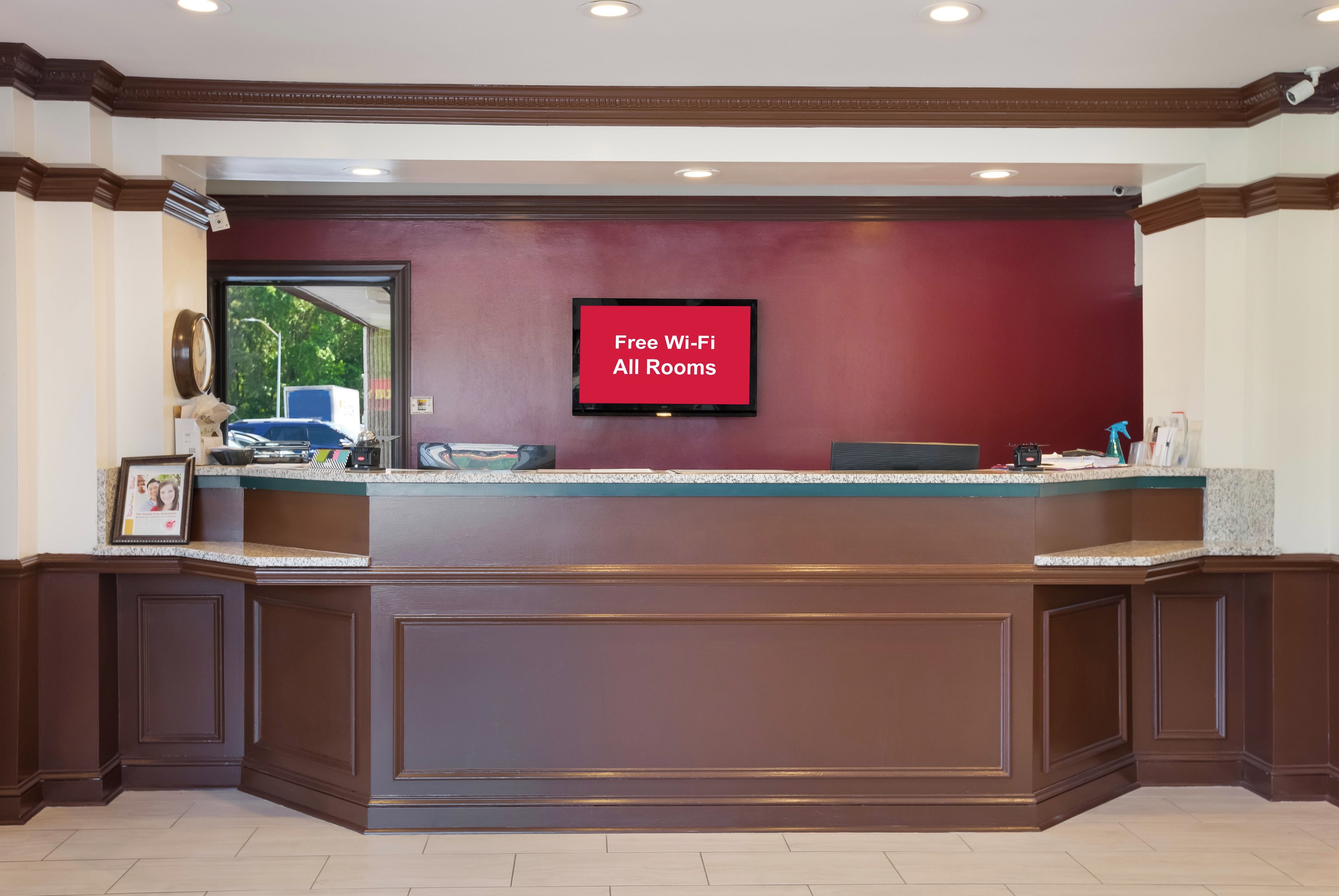 A reception desk with a digital screen displaying 'Free Wi-Fi All Rooms'.