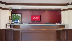 A reception desk with a digital screen displaying 'Free Wi-Fi All Rooms'.