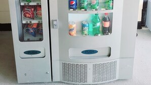 A vending machine with snacks and drinks, including chips, candy, and sodas.