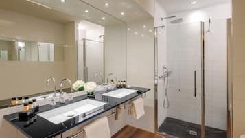 Un baño moderno con dos lavamanos, un espejo grande y una ducha con paredes de vidrio.