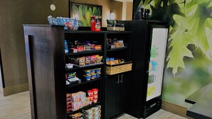 Una exhibición de aperitivos con diferentes alimentos envasados y un refrigerador.