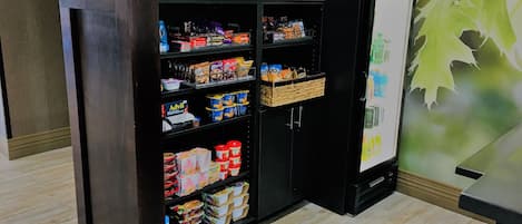 Una exhibición de aperitivos con diferentes alimentos envasados y un refrigerador.