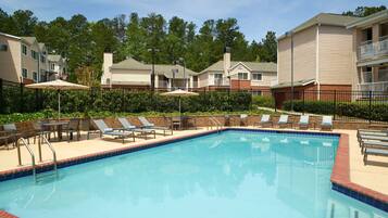 Una piscina al aire libre de temporada, sillones reclinables de piscina