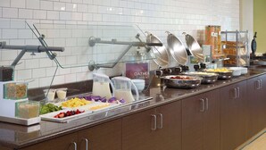 A buffet setup with various food items and utensils.