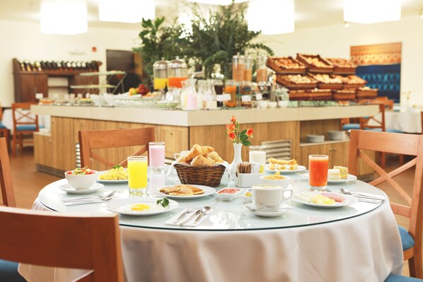 A breakfast buffet with various food items, a juice bar, and a selection of pastries. - San Agustin Exclusive Hotel (Lima)