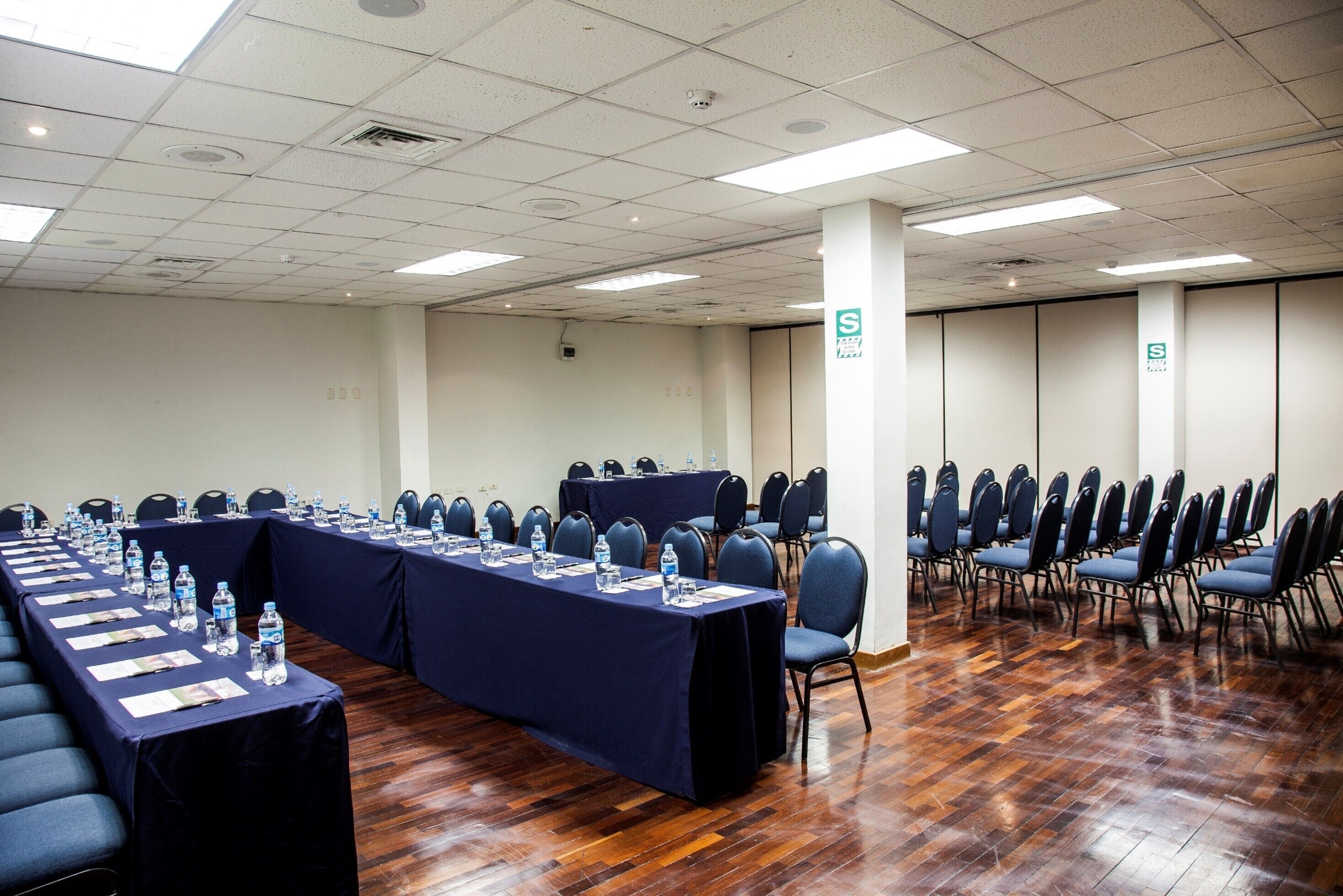 A conference room with a long table, chairs, and water bottles.