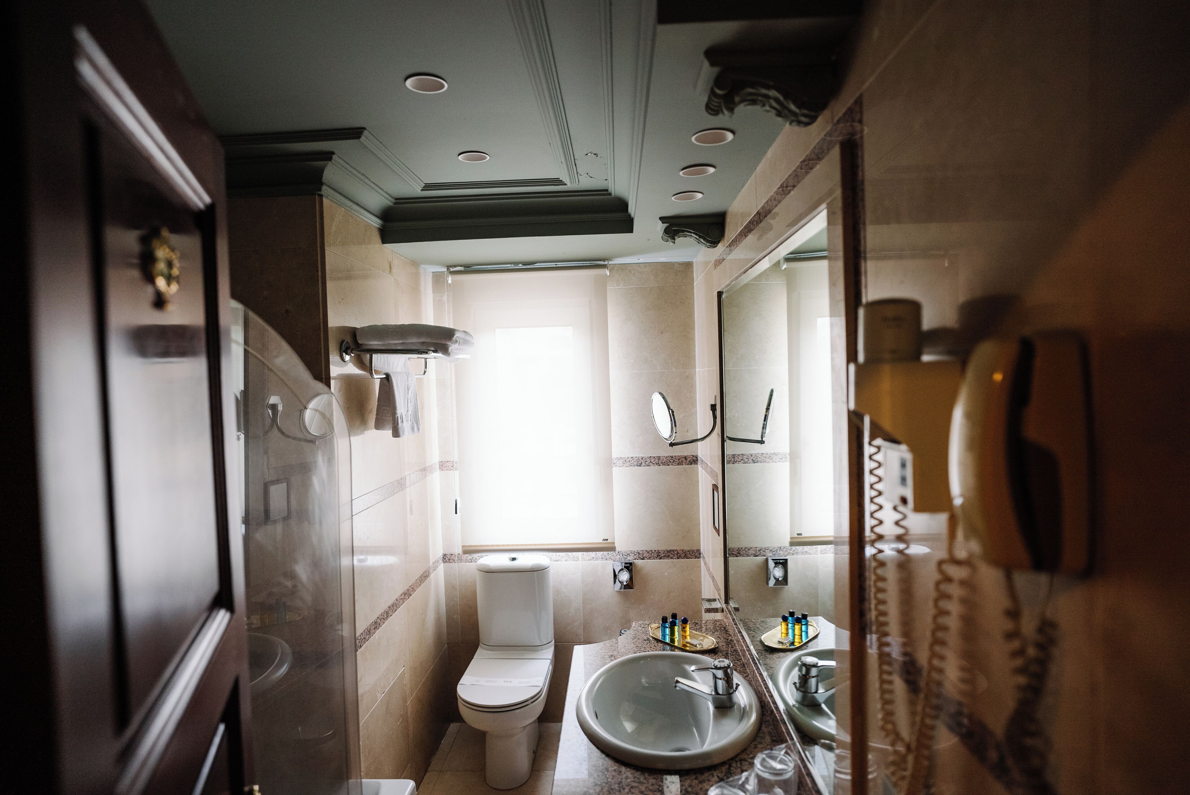 Un baño con inodoro, lavamanos y espejo.