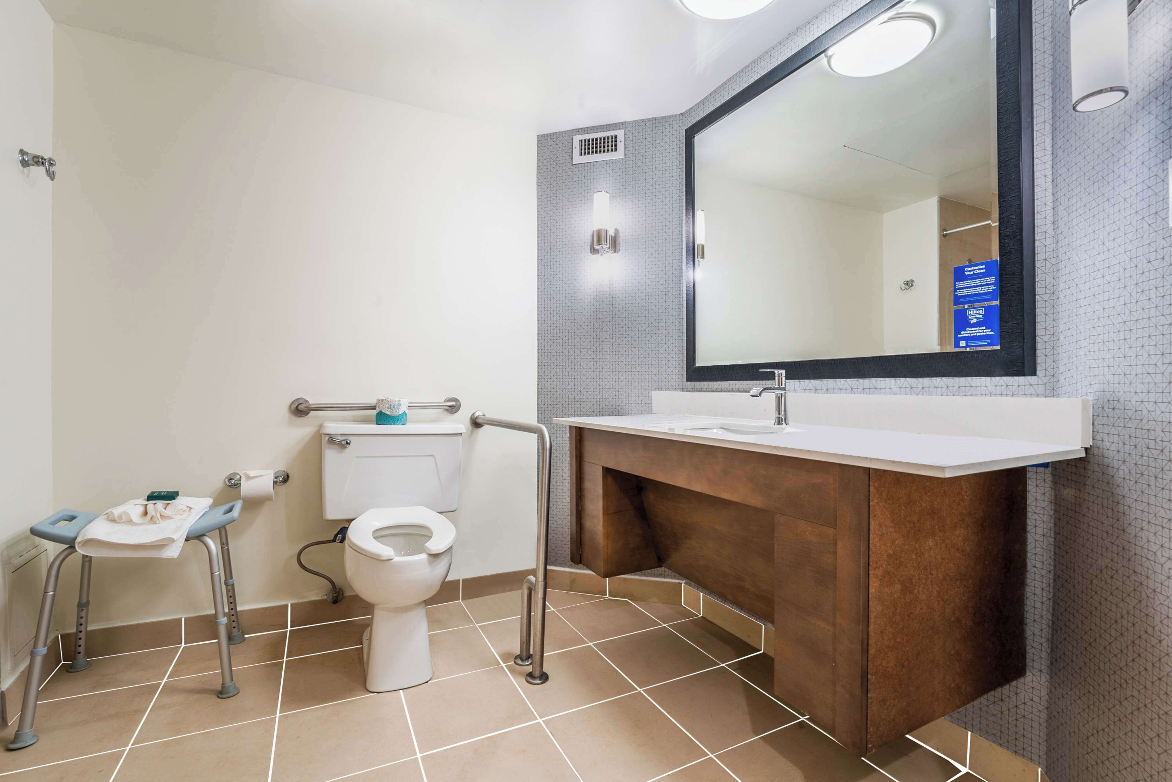 A modern bathroom with a toilet, sink, and mirror.