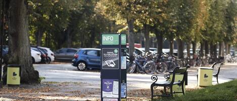 Un kiosque d’information sur les possibilités de stationnement, avec plusieurs panneaux et un banc à proximité.