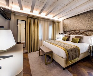 A hotel room with a bed, bedside table, lamp, and a mirror.