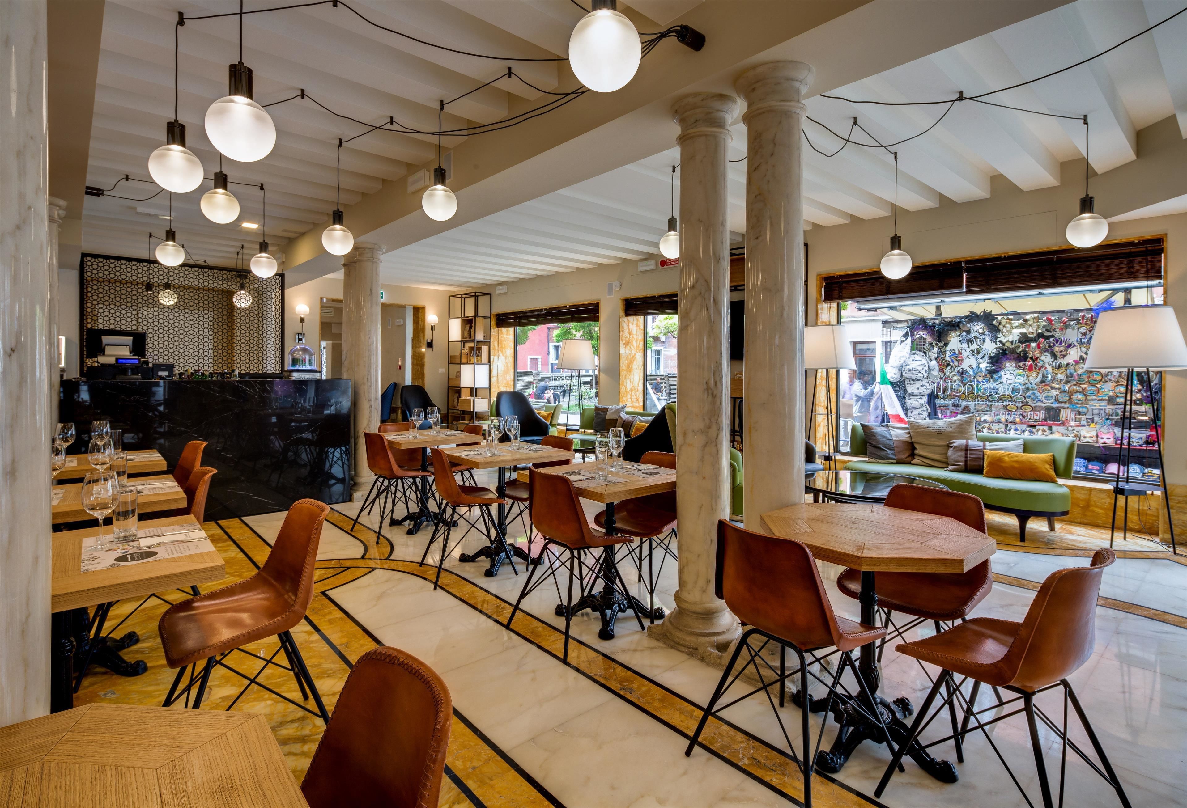 Un ristorante con pavimenti in marmo, tavoli in legno e sedie in pelle.