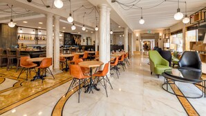 A spacious hotel lobby with marble flooring, multiple seating areas, and a bar with a variety of bottles. - CHC Continental, BW Premier Collection (Venice)