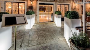 A hotel entrance with a stone floor, a reception desk, and a signboard. - CHC Continental, BW Premier Collection (Venice)