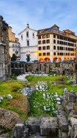 Un’antica rovina con un albergo sullo sfondo.