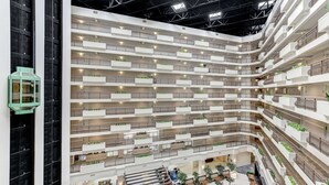Un atrium à plusieurs niveaux, doté de balcons, d’espaces de détente et de plantes d’intérieur.