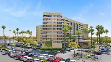 A multi-story building labeled "Embassy Suites" with a parking lot full of cars.