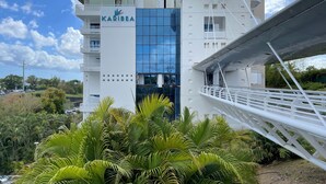 A modern hotel with a restaurant on the upper level, surrounded by lush greenery. - Karibea Valmenière Hôtel (Fort-de-France)