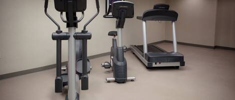 A fitness area with cardio machines including a treadmill and elliptical.