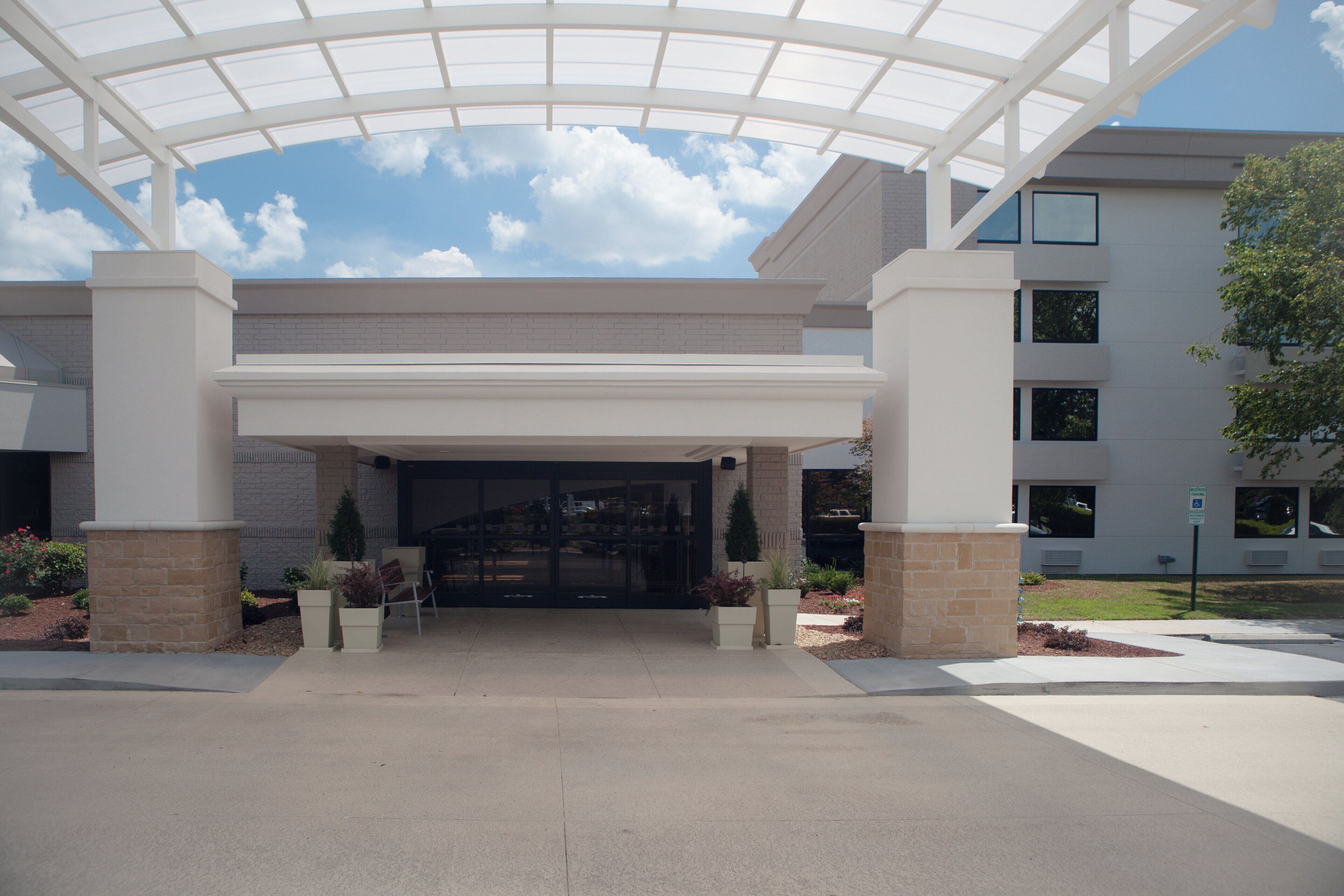 A building entrance with a covered walkway, brick walls, and a clear sky.