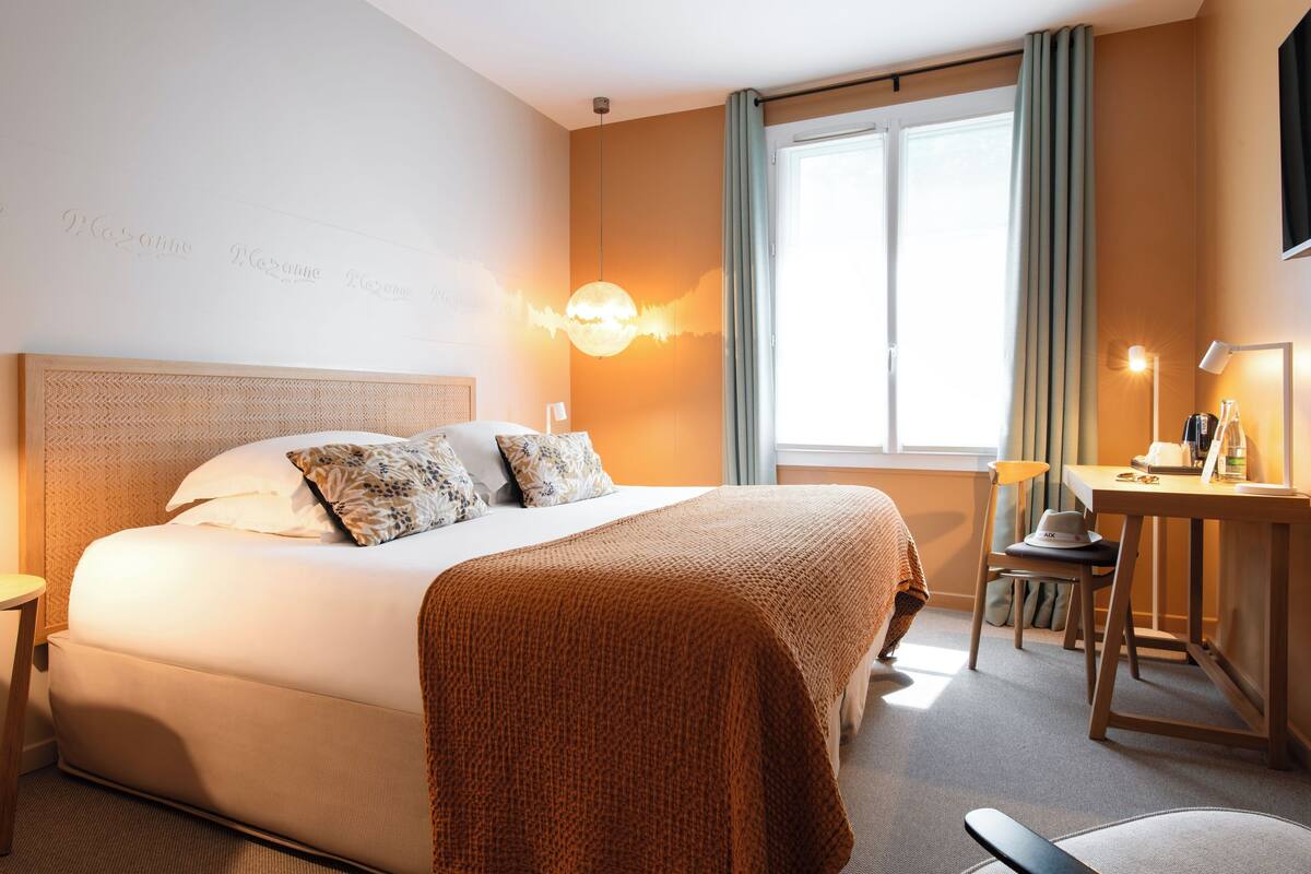 Une chambre d’hôtel avec un grand lit, un bureau et une chaise.