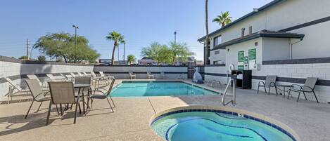 A pool area with lounge chairs and a small pool.